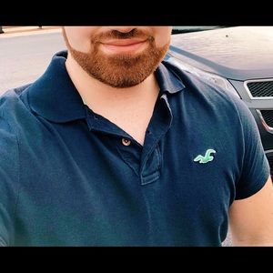 HOLLISTER navy polo with green seagull logo.